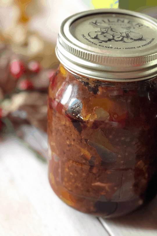 Instant Pot Lime Pickle in a screw top Kilner glass jar with a golden lid on a light coloured wooden table with dried leaves and berries in the background