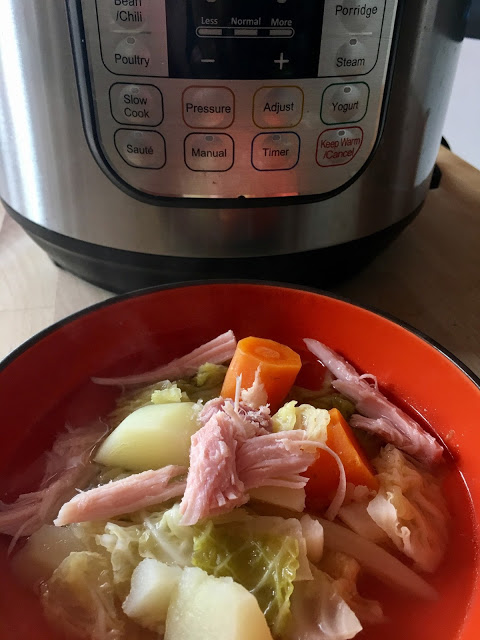 Photo: an orange bowl with the ham and cabbage soup with an Instant Pot Duo in the background