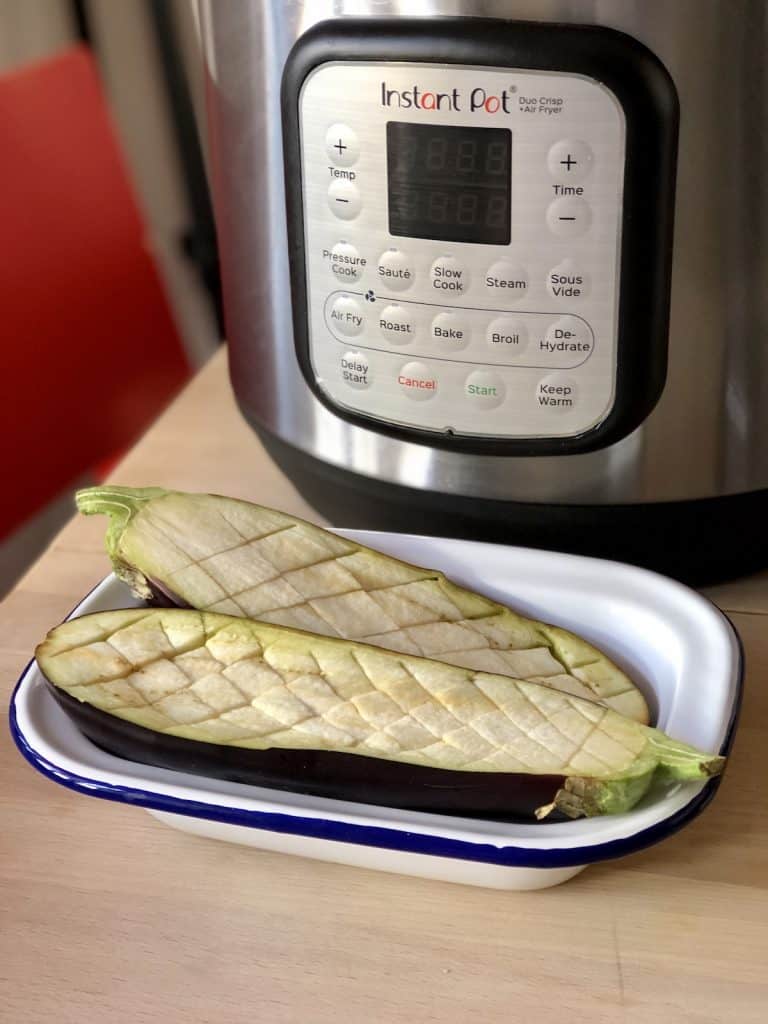 Aubergine sliced lengthways and with crisscross pattern ready to glaze in Instant Pot Duo Crisp