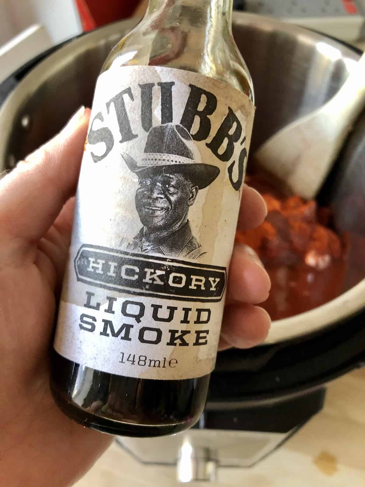 Photo of a bottle of the Stubbs Liquid Hickory Smoke recommended for the Easy Instant Pot BBQ Pulled Pork recipe by Feisty Tapas