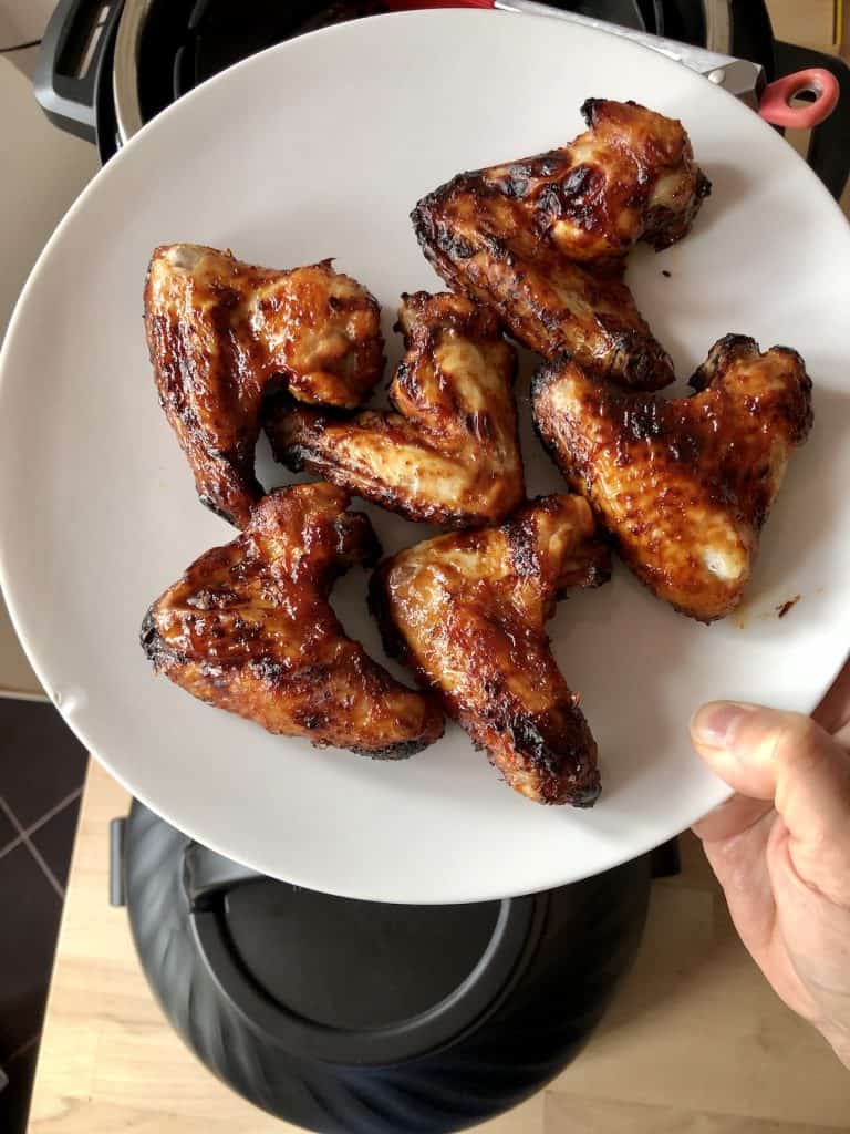 Instant Pot BBQ Chicken wings on a white plate. Recipe by Feisty Tapas