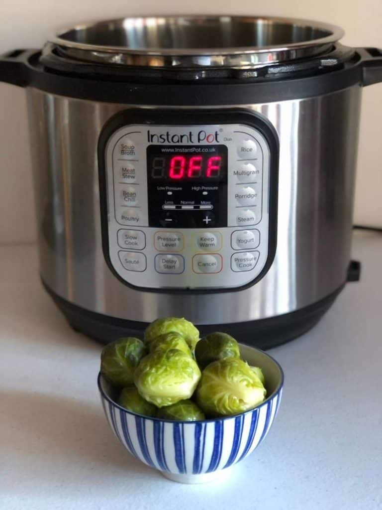How to pressure cook brussels sprouts - in blue and white striped bowl with Instant Pot duo in the background