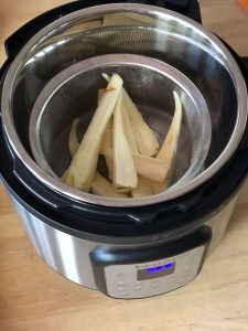 Prepared parsnips in mesh steamer basket in the inner pot of the Instant Pot Duo Crisp