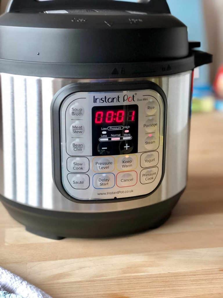 Instant Pot Duo Mini on wooden kitchen table - pressure cooker recipe index