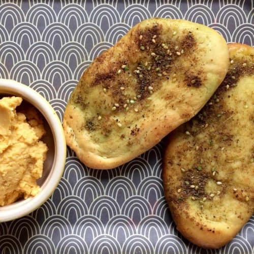 Thermomix Za'atar Flatbreads served with hummus on a grey and white patterned background