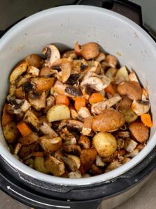 All ingredients for mushroom stew seen inside the inner pot of the Ninja Foodi 9 in 1, ready to close the lid and pressure cook