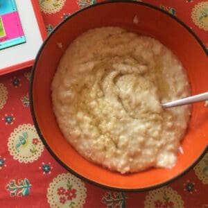 Thermomix Porridge for one seen from above inside an orange bowl