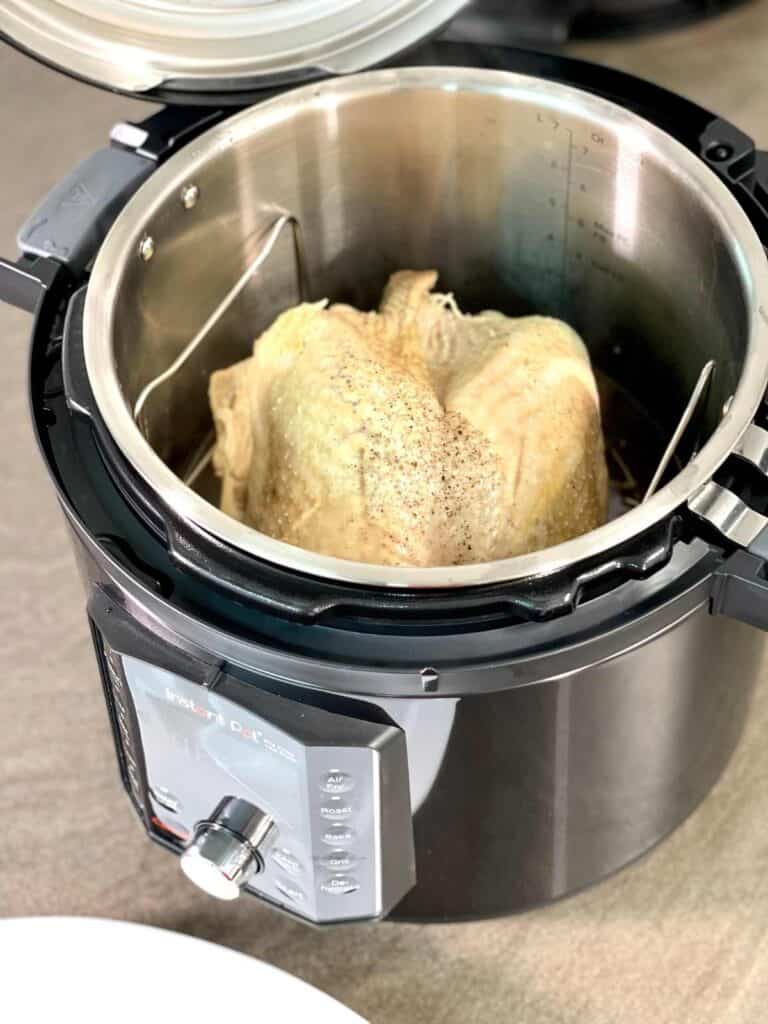 Turkey crown inside the Instant Pot Pro Crisp right after pressure cooking, seen from above at an angle on a brown surface