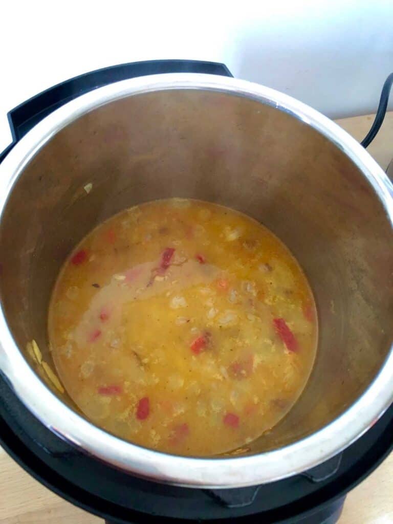 After stirring the stock and before pressure cooking, seen from above inside the pot