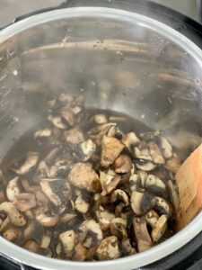 Stirring the garlic mushrooms after pressure cooking seen from above in the stainless steel inner pot of the Instant Pot Duo multicooker