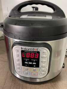 Instant Pot Duo showing L0.03 on the display screen, meaning it has been on keep warm for 3 minutes. On a taupe brown kitchen counter