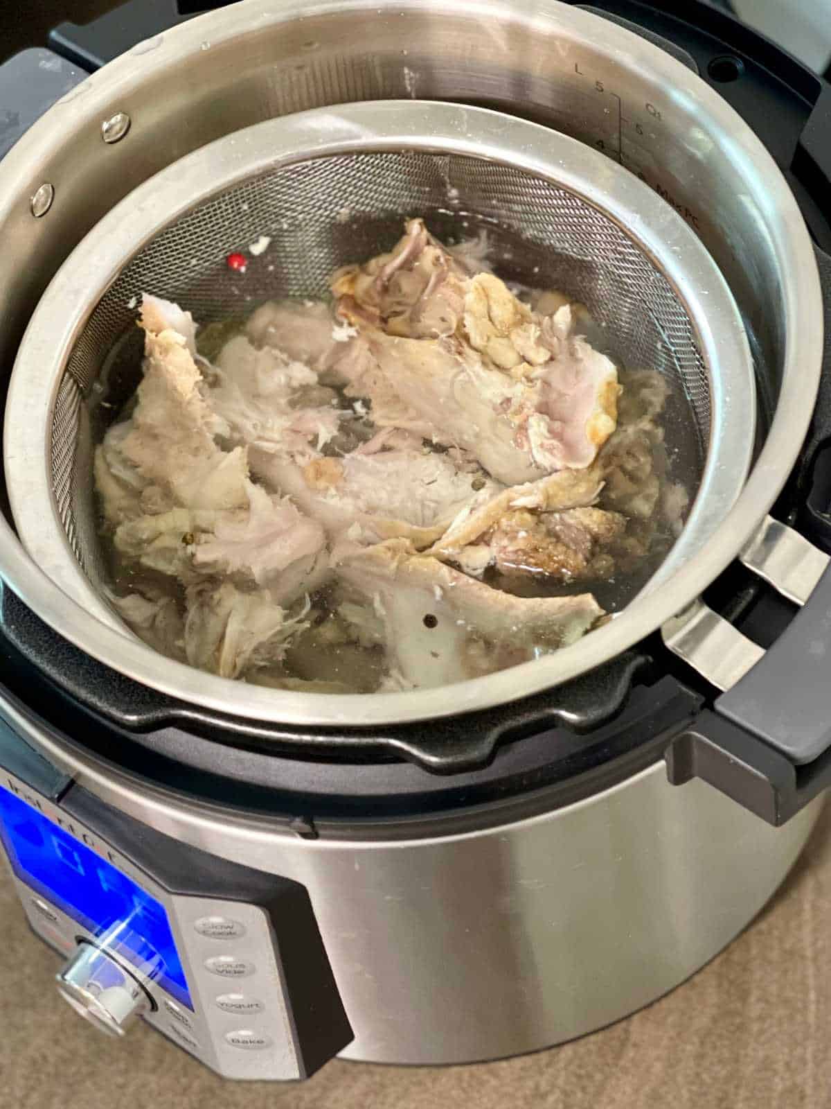 bones in mesh sieve seen from the top inside an Instant Pot Duo Evo Plus - for pressure cooker turkey stock