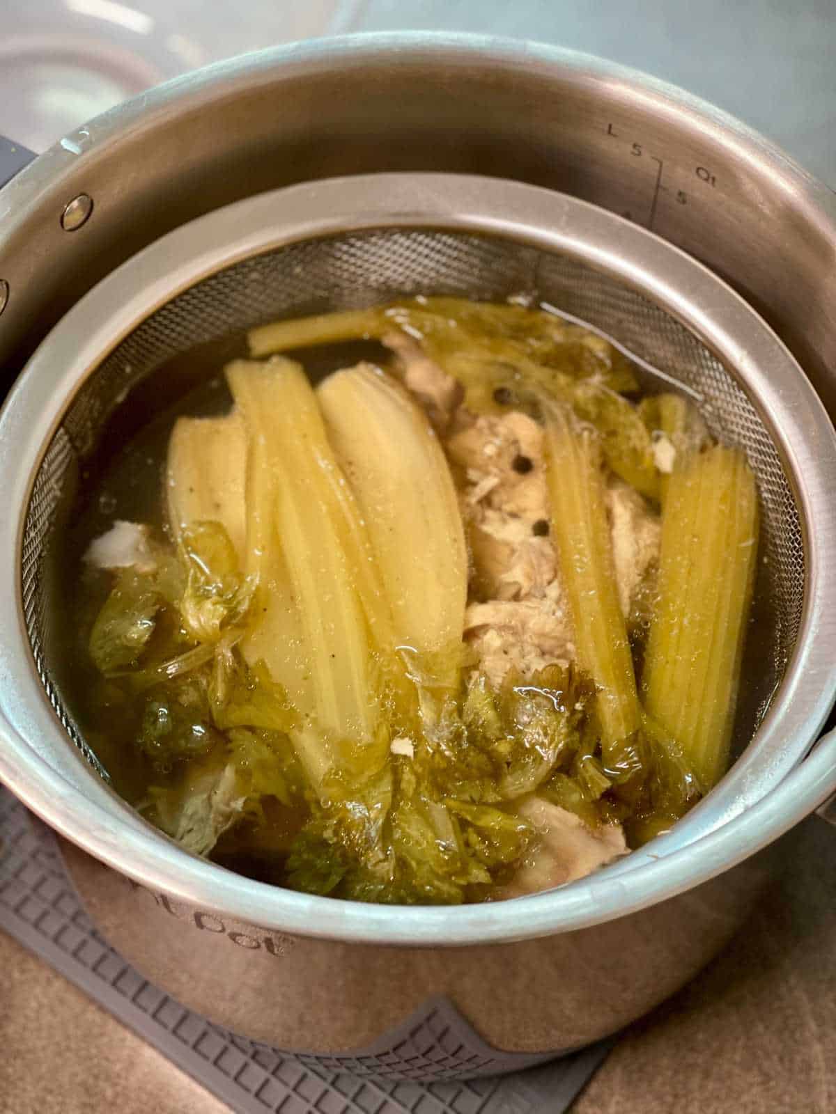 Pressure cooked turkey stock seen from above inside the stainless steel inner pot of an electric pressure cooker (Instant Pot)