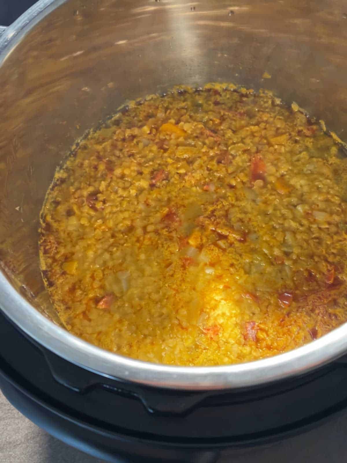 Chorizo and Red Lentil Soup just pressure cooked, seen from above inside the stainless steel inner pot of an Instant Pot