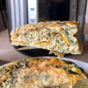 Photo of a slice of chard and sweet potato frittata held up int the air with an Instant Pot Duo Evo Plus in the background