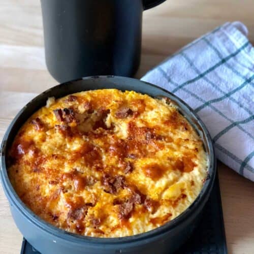 Photo of Instant Pot Chorizo Frittata seen from above on a wooden table with a tea towel on the top right of the photo