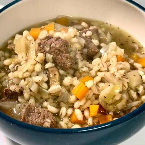 Photo of Pressure Cooker Beef and Pearl Barley Stew in a blue bowl, white on the inside