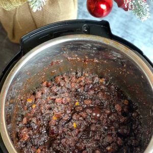 Photo of Pressure Cooked Christmas Mincemeat seen from above with the leaves of a Christmas tree and a bauble on the top of the photo