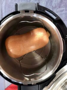 Photo of a whole butternut squash inside a pressure cooker
