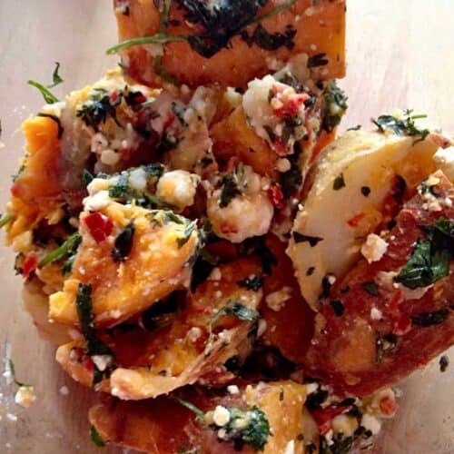 Photo of the Thermomix potato salad with the bright sweet potatoes seen from above coated in feta, red chilli and fresh coriander leaves