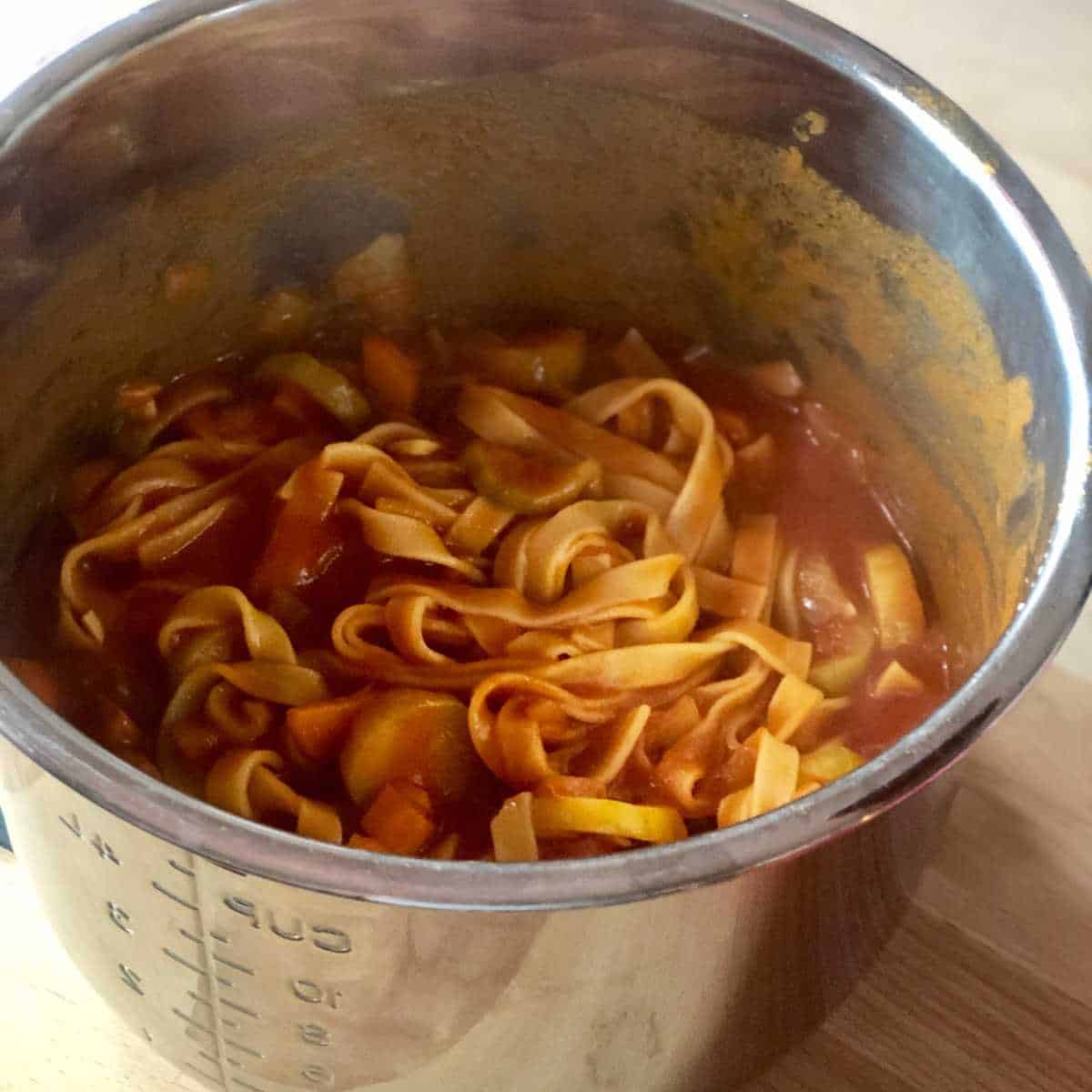 Photo of the pressure cooked chorizo tagliatelle pasta seen still inside the Instant Pot's stainless steel inner pot