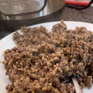 Photo of pressure cooked haggis on a white plate with an Instant Pot Duo in the background
