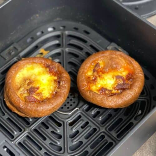 Photo of twwo mini Yorkshire puddings loaded with cheese and chorizo seen from above inside the Instant Vortex air fryer basket
