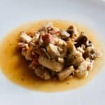 Photo of the pressure cooked Chicken and Serrano Ham surrounded by jus on a white plate