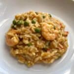 Photo of the Instant Pot Prawn, Trout and Pea Risotto with the rice, peas and a couple of king prawns ready to eat served on a white plate