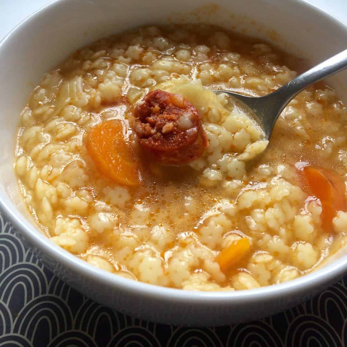 Photo of the pasta soup served in a white bowl, the star pasta and the chorizo make it very tempting