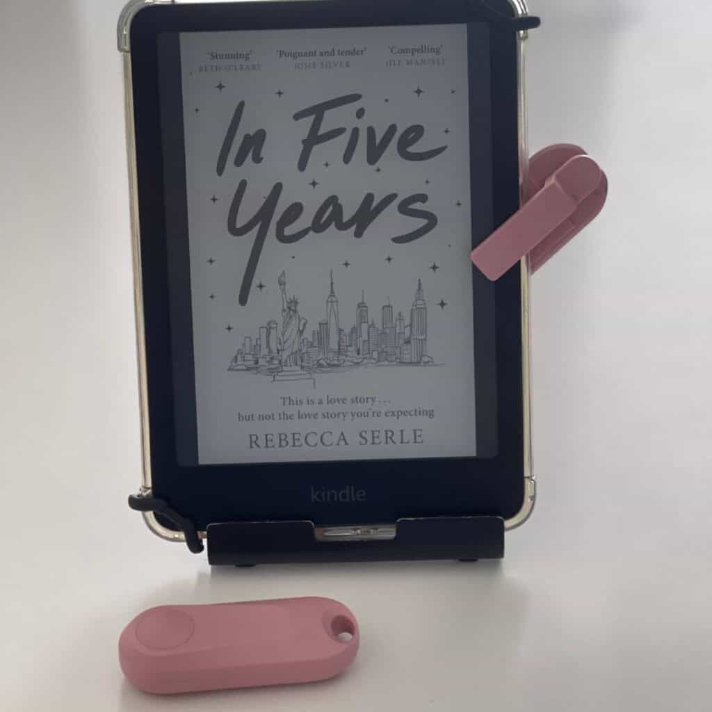 Photo of a Kindle Paperwhite with a pink page turner with the book In Five Years by Rebecca Serle as a book cover