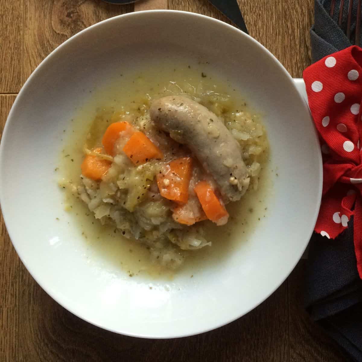 The sausage and apple casserole served on a white plate, should you need a good giggle it might be handy to know that the sausage looks rather phallic