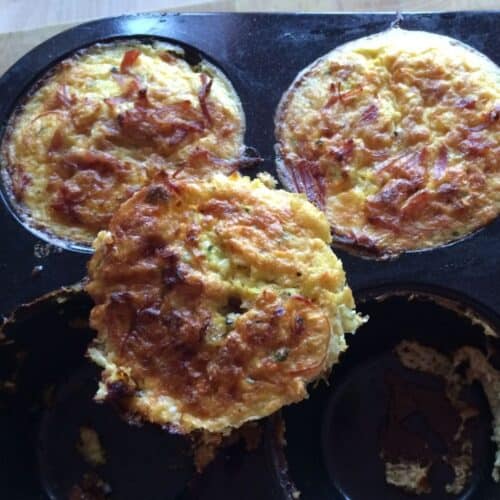 Photo of the Thermomix Ham Hock Egg Muffins, two are still inside the muffin tin and one is propped on it