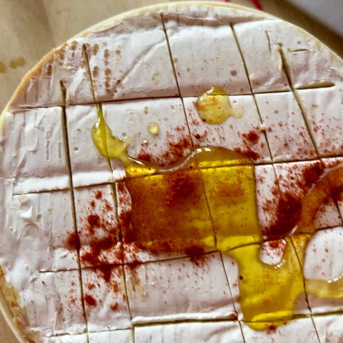 whole camembert topped with olive oil and paprika