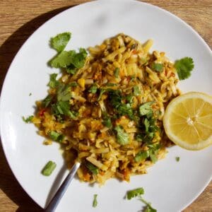 Noodles on a white place with half a lemon on the right hand side