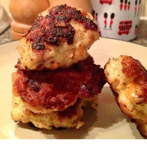 A stack of 3 chicken burgers with a fourth one leaning against the stack on the right