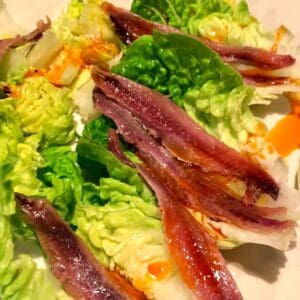Gem Lettuce leaves topped with anchovies and chorizo juices